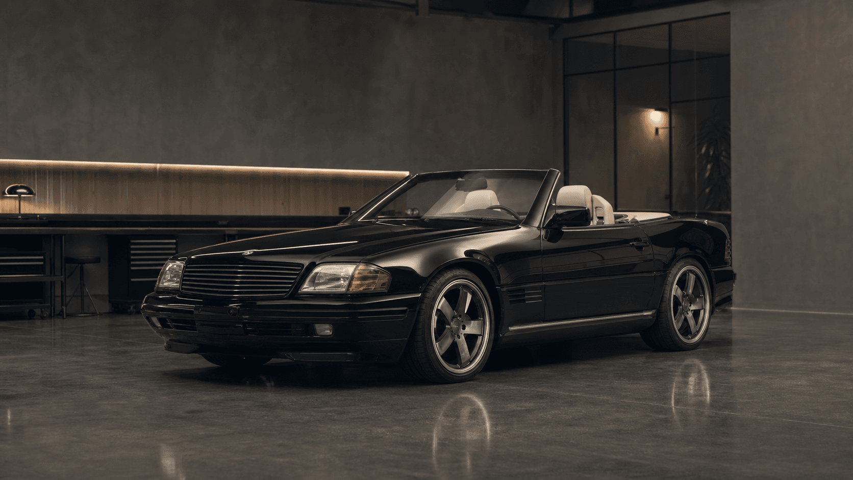 Black 1992 Mercedes SL-style roadster in a private automotive atelier